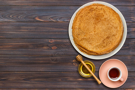 热煎饼和蜂蜜在盘子上图片