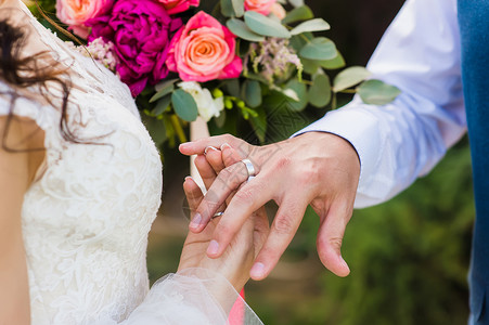 夫妻在婚礼时交换结婚戒指在户外图片