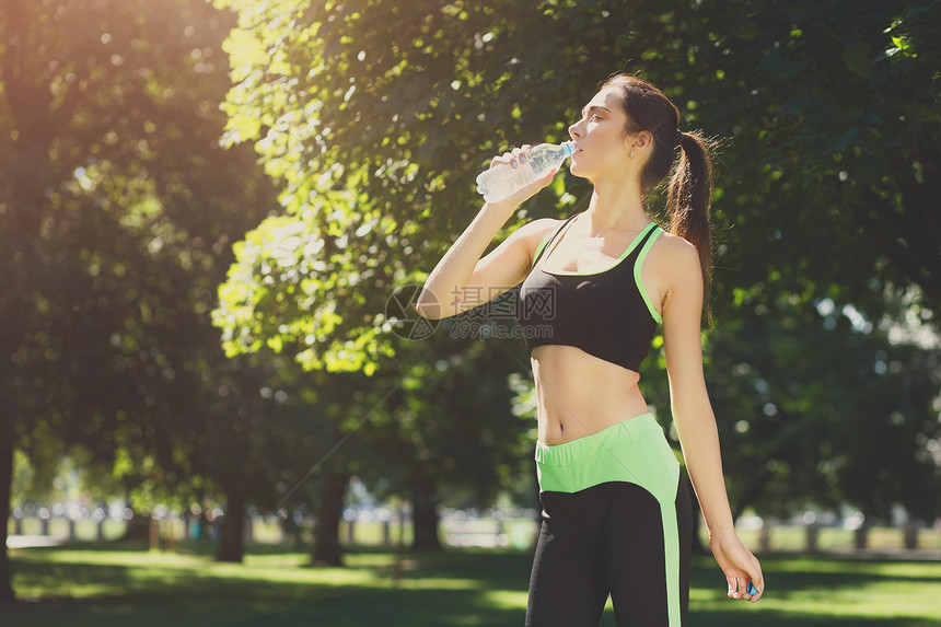 筋疲力尽的女人在户外训练后穿着服从瓶子里喝水舒展健康平静放松积极的图片
