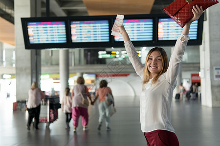 带着护照和罚单站着的快乐年轻女孩举起手来图片