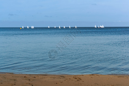 远处水上的中型游艇带白帆的赛艇图片