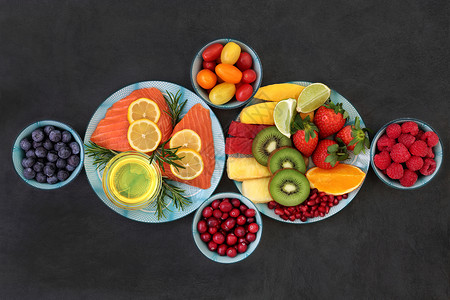 健康概念的健康营养与新鲜鲑鱼水果蔬菜草药和橄榄油的超级食物图片