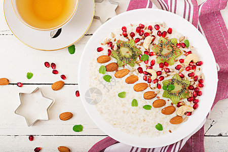 美味健康的燕麦粥配猕猴桃石榴和种子健康的早餐健身食品适当的图片