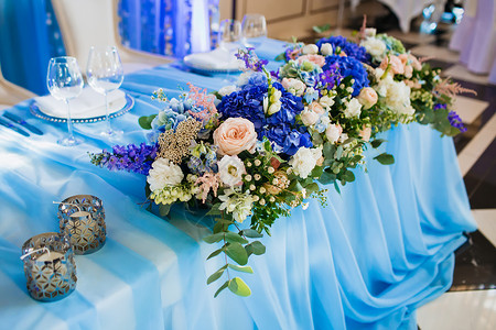 婚礼宴会装饰美工软体专注于蓝桌布上带有废品的花图片