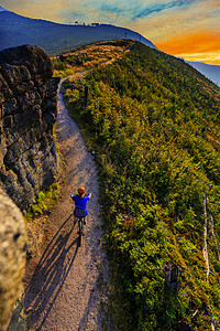 山地自行车妇女在夏季山区森林景观中骑自行车骑自行车MTB流径的女人图片