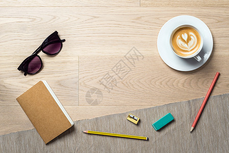 黑色眼镜和咖啡放在办公桌上图片