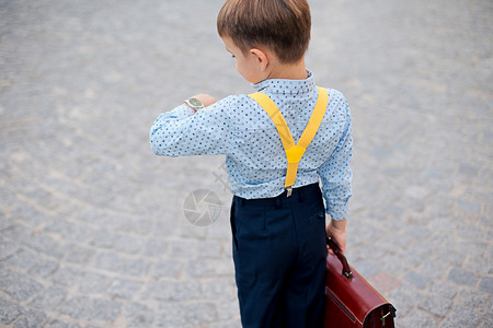 黑暗蓝裤子的后视男孩婴儿蓝衬衫和黄色带子图片