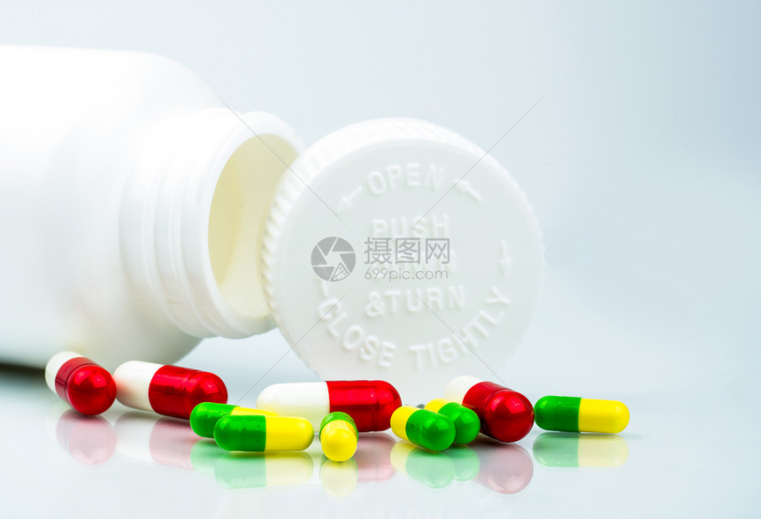 白色背景上的彩色药丸和带有空白和复制空间的塑料瓶儿童安全包装儿童抗药丸容器向下推并转动上限全球图片