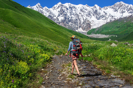 一个背包大起的游客在一条山路上登山路背景图片