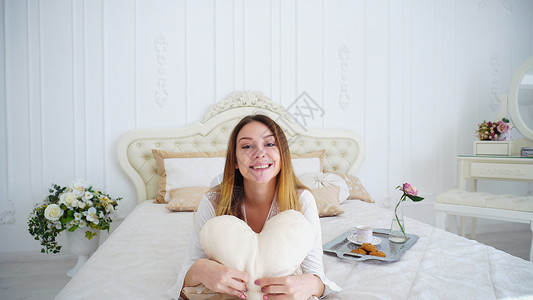 在美丽的米色双人床与枕头在白色的房间图片