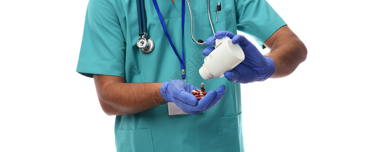 男医生吃药片在白色背景下被隔离图片