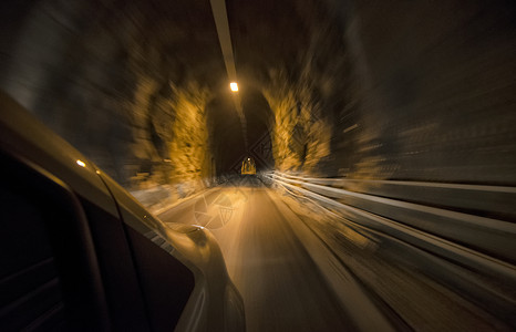 汽车在雕刻的隧道内全速行驶图片