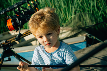 带着惊讶的脸在河上钓鱼的小孩钓鱼码头上拿着鱼竿的男孩暑假图片