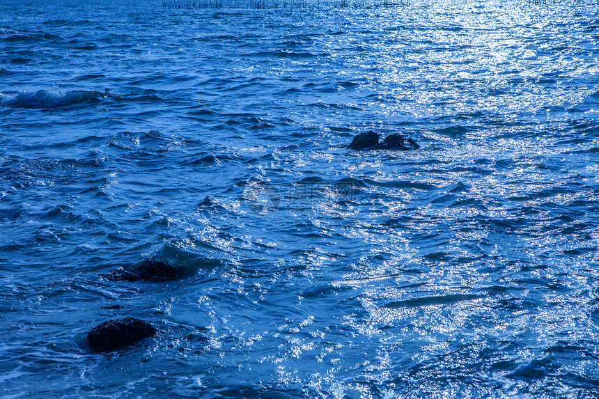 海中的岩石海浪撞击海中的岩石海滩上的岩石海反射太阳图片