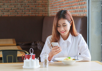 开心女人在餐厅吃午饭打电话图片