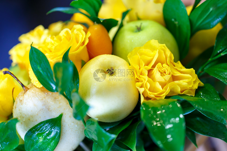 由苹果柠檬库姆夸特和黄色玫瑰组成的美丽的手工花图片