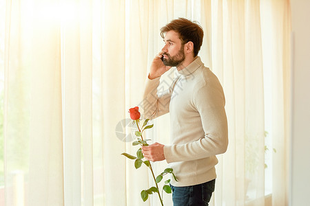 男人拿着玫瑰和手机室内帅哥图片