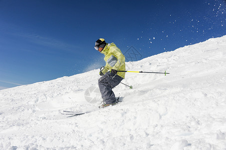 身穿黄色和灰色运动服的滑雪男子图片