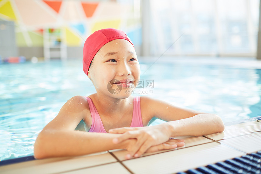 穿着泳装的亚洲快乐女孩在训练期间站在游泳图片
