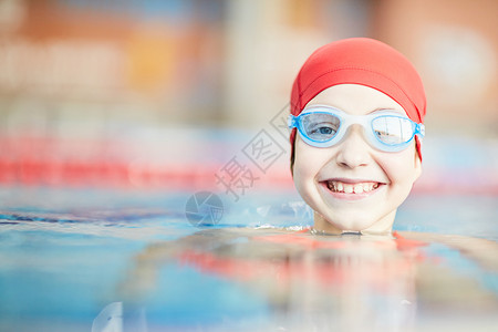 快乐的年轻游泳运动员在护目镜和游泳池水图片
