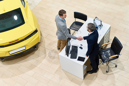 在展厅成功进行汽车交易后与顾客握手图片