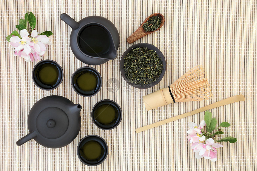 日本senchasukiygumakoto茶与壶叶子杯子拂子搅拌棒和竹背景上的春花有许多健康益处图片