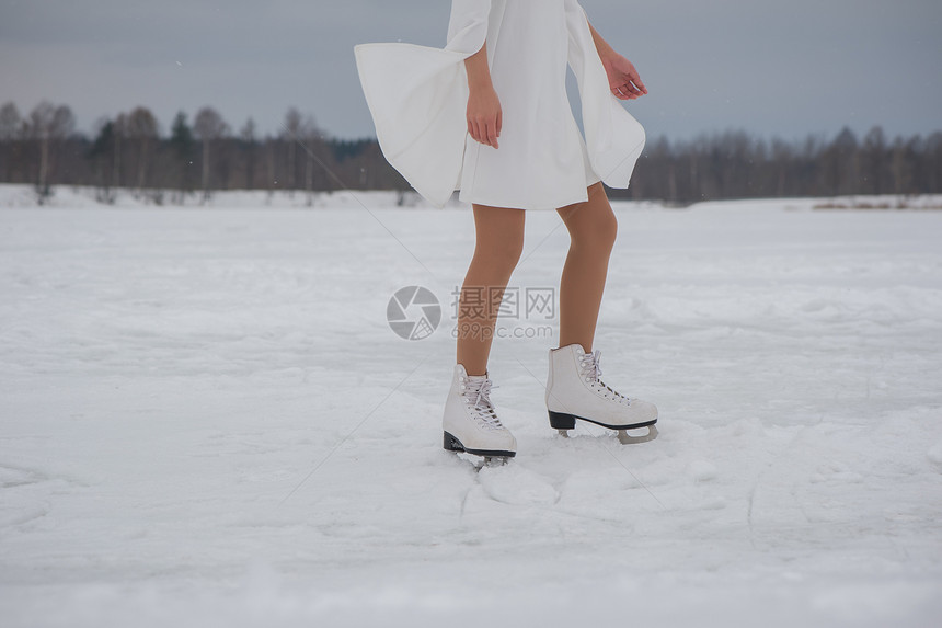 冬天穿白衣服和溜冰在户外雪地上露天滑图片