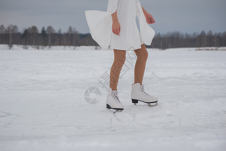 冬天穿白衣服和溜冰在户外雪地上露天滑图片