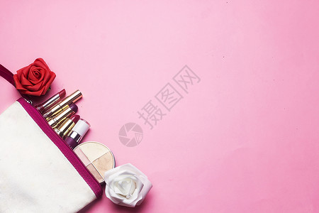 化妆包里有不同颜色的口红和粉红色背景上红色和白图片