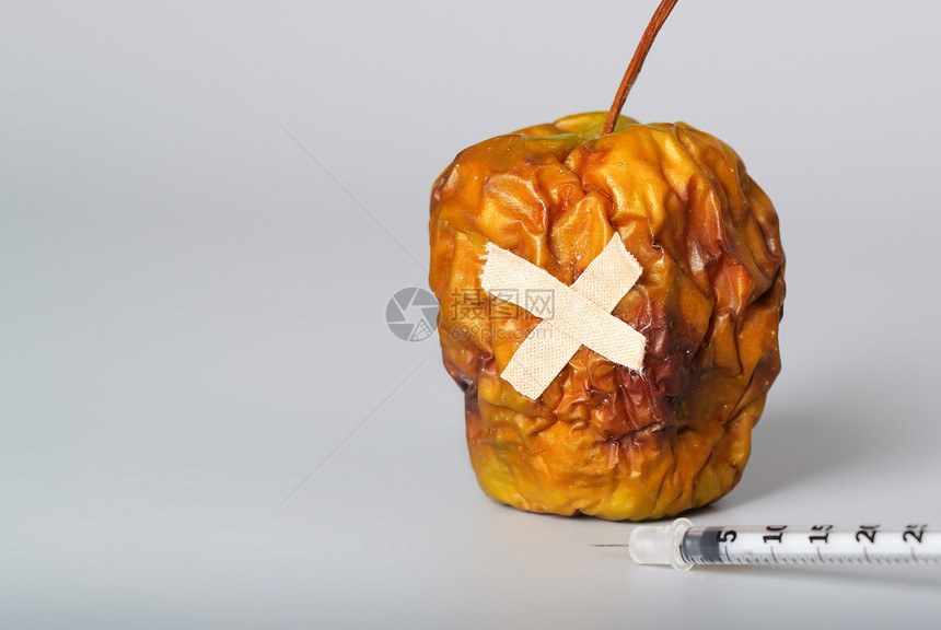 灰色表面上的干苹果和胰岛素超薄注射器特写图片