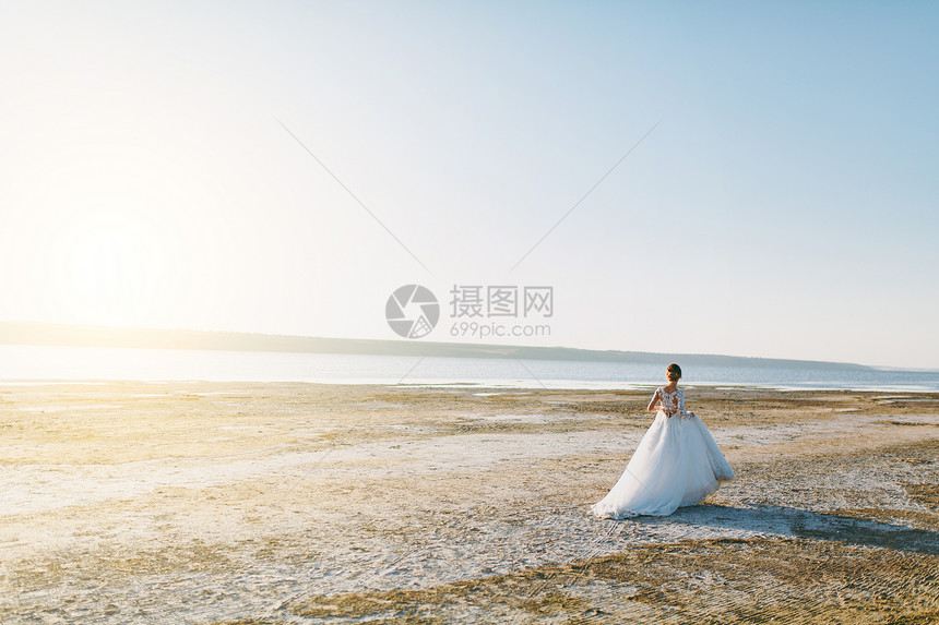 年轻可爱优雅身材匀称的新娘穿着白色蕾丝连衣裙图片