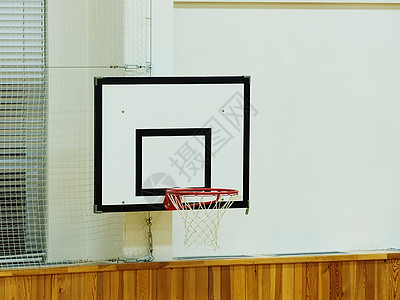 旧的篮球架和白色学校健身房的墙壁背景图片