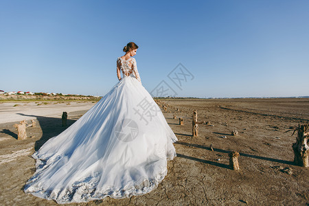 年轻可爱优雅身材匀称的新娘穿着白色蕾丝连衣裙背景图片