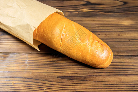 木桌上纸袋法式长棍面包图片