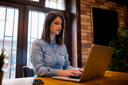 微笑的女使用连接到无线互联网的笔记本电脑设备工作图片