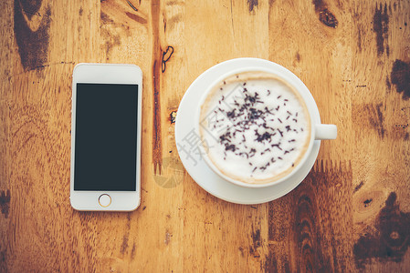 咖啡和智能手机放在咖啡厅的木制桌上咖啡图片