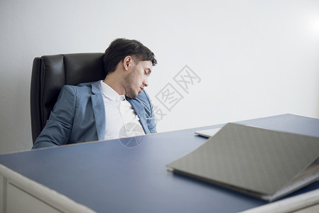 商人累了劳累过度睡在办公桌上图片