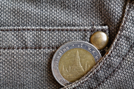 破旧的棕色牛仔裤口袋里有10泰铢的泰国硬币图片