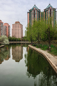 团结湖公园公园内的池塘景观与相邻的房屋和反映在水中的高楼图片