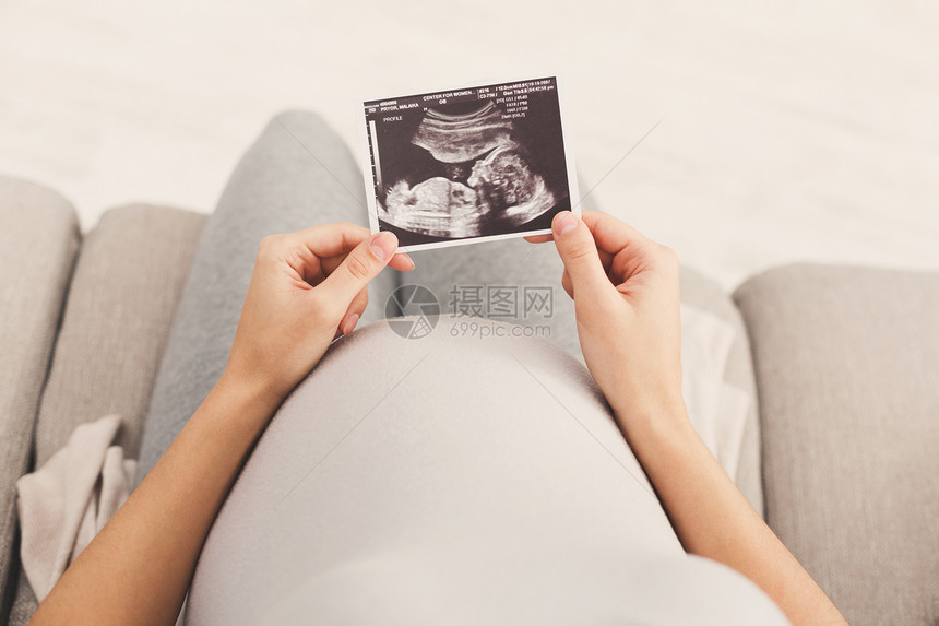 无法辨认的期待女士享受她未出生孩子的第一张照片图片