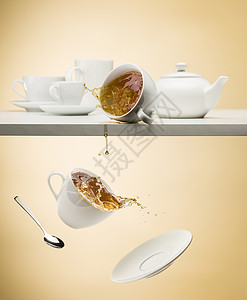 茶壶和碟子从白桌掉下图片