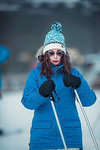 穿着蓝色夹克和墨镜的冬季运动女郎图片