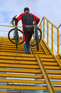 一个男人拿起两辆自行车上楼梯图片