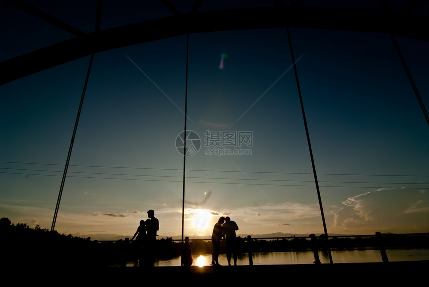 爱情的侣双休眠在日落时在桥上图片