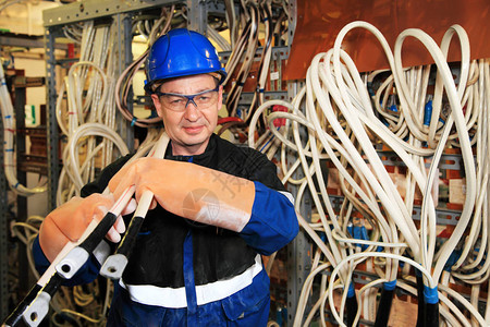 电气安全手套中的机电人员持有电力缆工业配电熔断器中高压电力图片