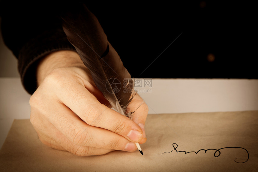 作家拿着钢笔在书写纸和签名特写镜头图片