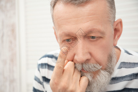 高年男子把隐形眼镜图片