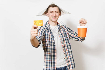 年轻微笑英俊的男人在报纸帽子拿着信用卡和空油漆桶与副本空间隔离在白色背景背景图片