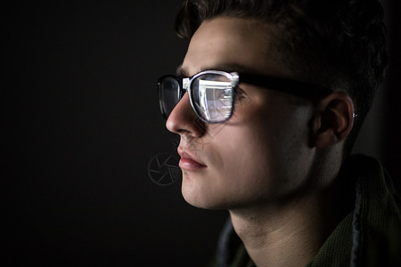 使用平板电脑用黑边眼镜戴黑边眼镜的严肃青年的眼睛图片