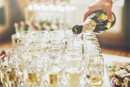 服务员在豪华婚宴上用时尚的眼镜倒香槟丰富的庆祝活动盛宴上昂贵的餐饮和服务新年和圣诞节庆背景图片
